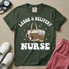 A Labor and Delivery nurse graphic featuring a large beige tote bag with a leopard print pocket, a stethoscope draped over it, and a large iced coffee cup with a matching leopard print sleeve, all surrounded by white text that reads LABOR & DELIVERY curved above and NURSE below.