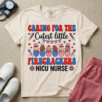 A cute Neonatal Intensive Care Unit nurse graphic featuring a row of diverse babies wrapped in patriotic red, white, and blue star-spangled and striped swaddles, with some wearing top hats, surrounded by fireworks and star bunting, alongside retro text reading CARING FOR THE Cutest little FIRECRACKERS NICU NURSE.