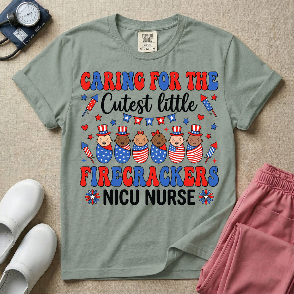 A cute Neonatal Intensive Care Unit nurse graphic featuring a row of diverse babies wrapped in patriotic red, white, and blue star-spangled and striped swaddles, with some wearing top hats, surrounded by fireworks and star bunting, alongside retro text reading CARING FOR THE Cutest little FIRECRACKERS NICU NURSE.