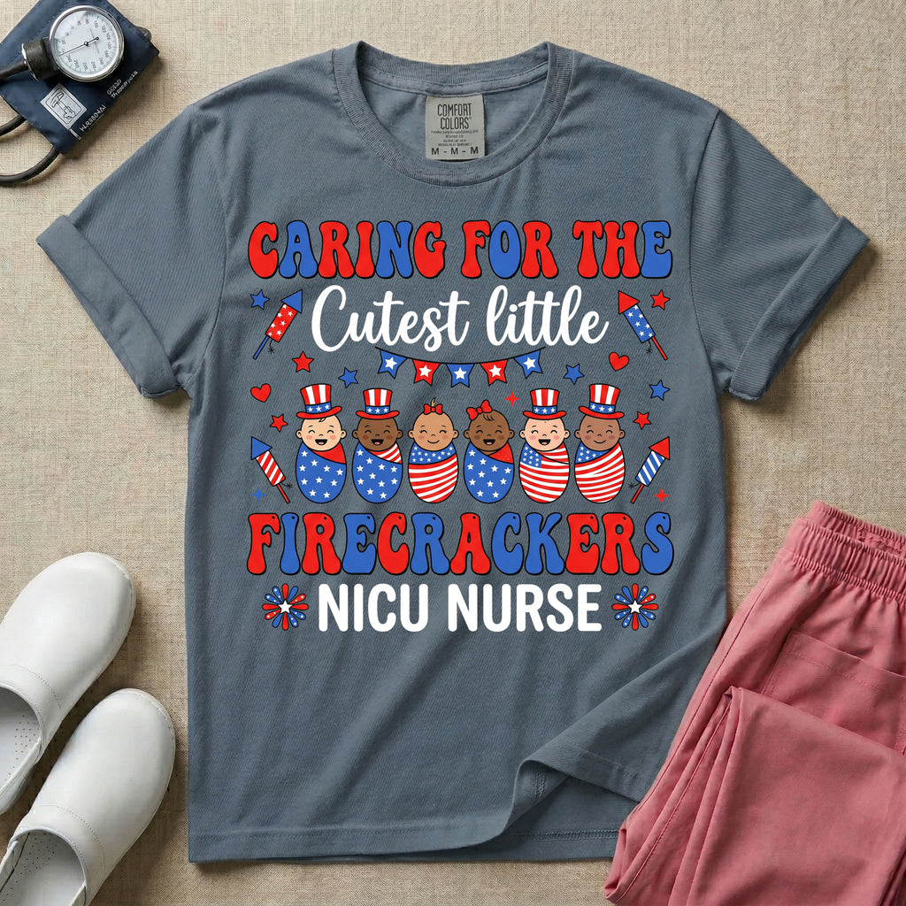 A cute Neonatal Intensive Care Unit nurse graphic featuring a row of diverse babies wrapped in patriotic red, white, and blue star-spangled and striped swaddles, with some wearing top hats, surrounded by fireworks and star bunting, alongside retro text reading CARING FOR THE Cutest little FIRECRACKERS NICU NURSE.