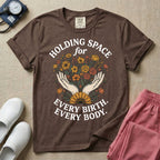 A Labor and Delivery and Doula graphic featuring an illustration of two open hands gently holding a bouquet of wildflowers with a large sunflower at the base, surrounded by white text that reads HOLDING SPACE for above and EVERY BIRTH. EVERY BODY. below.