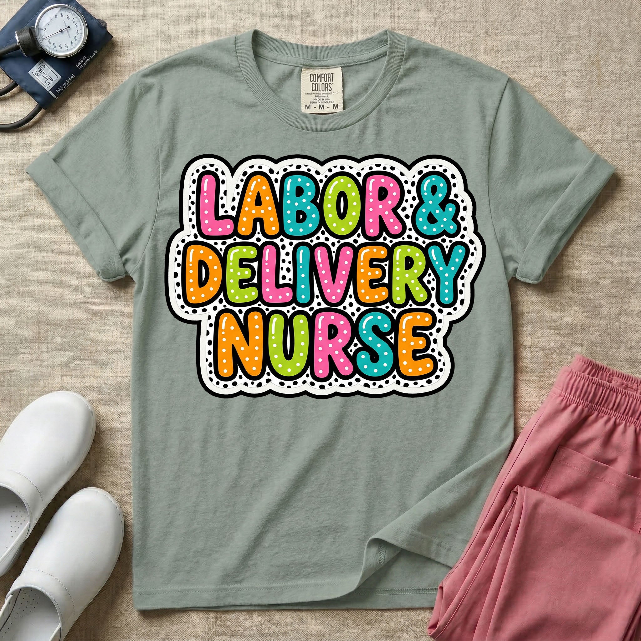 A graphic t-shirt for a Labor and Delivery unit featuring the text 'LABOR & DELIVERY NURSE' in bright, multicolored bubble lettering with white dots, framed by a contrasting black and white spotted background pattern.