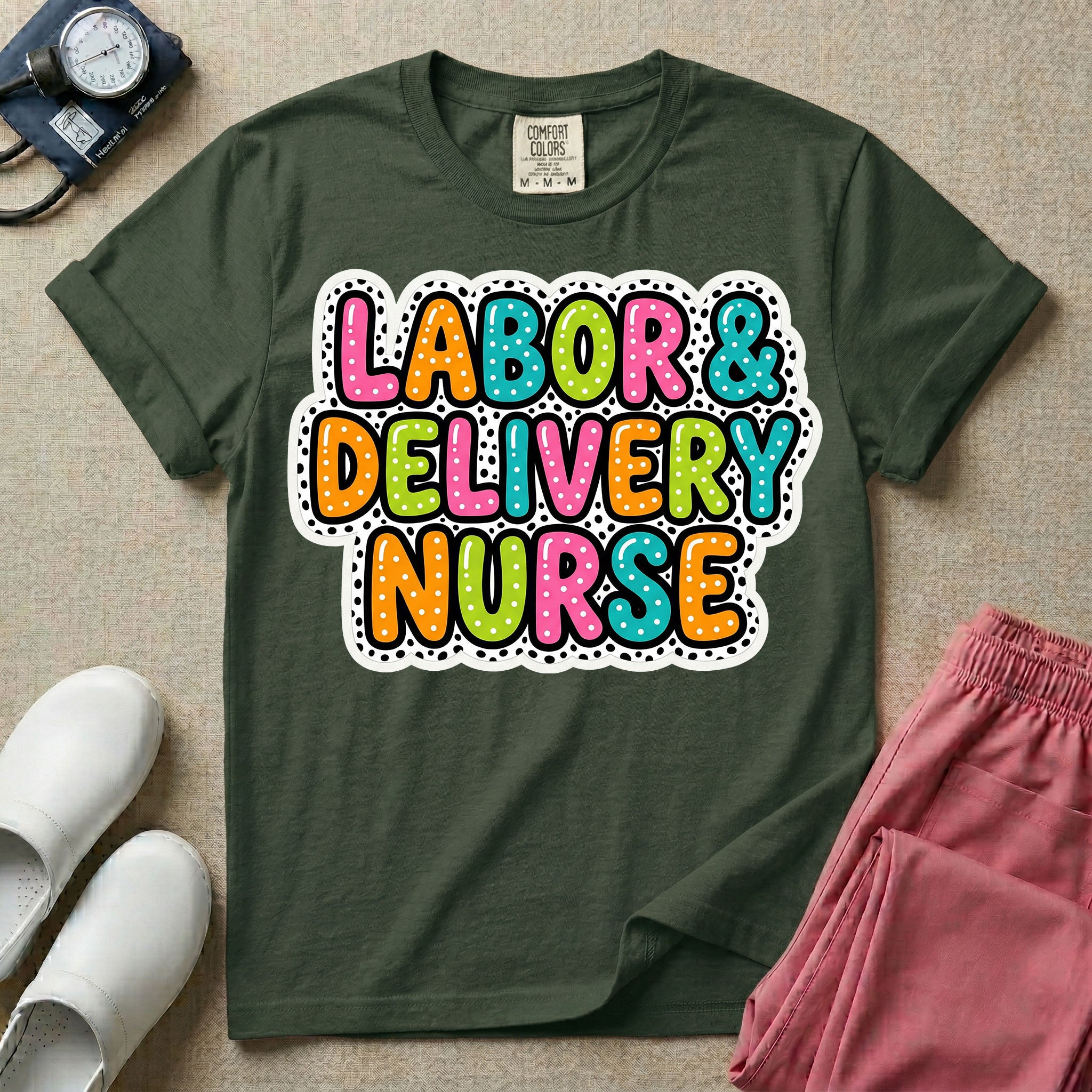 A graphic t-shirt for a Labor and Delivery unit featuring the text 'LABOR & DELIVERY NURSE' in bright, multicolored bubble lettering with white dots, framed by a contrasting black and white spotted background pattern.
