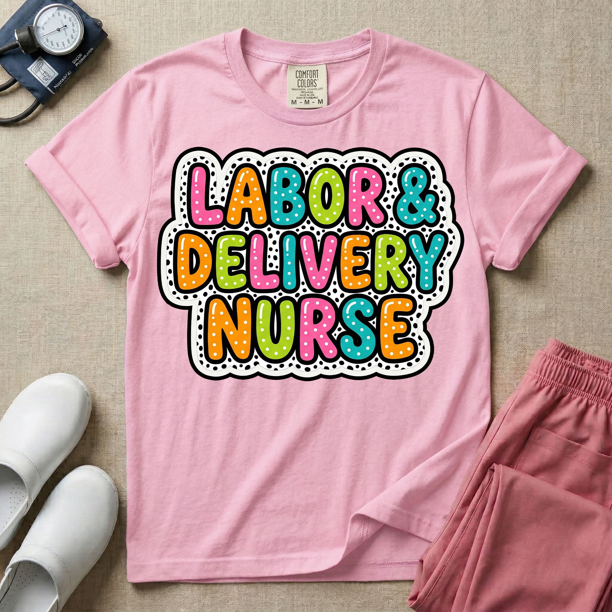 A graphic t-shirt for a Labor and Delivery unit featuring the text 'LABOR & DELIVERY NURSE' in bright, multicolored bubble lettering with white dots, framed by a contrasting black and white spotted background pattern.