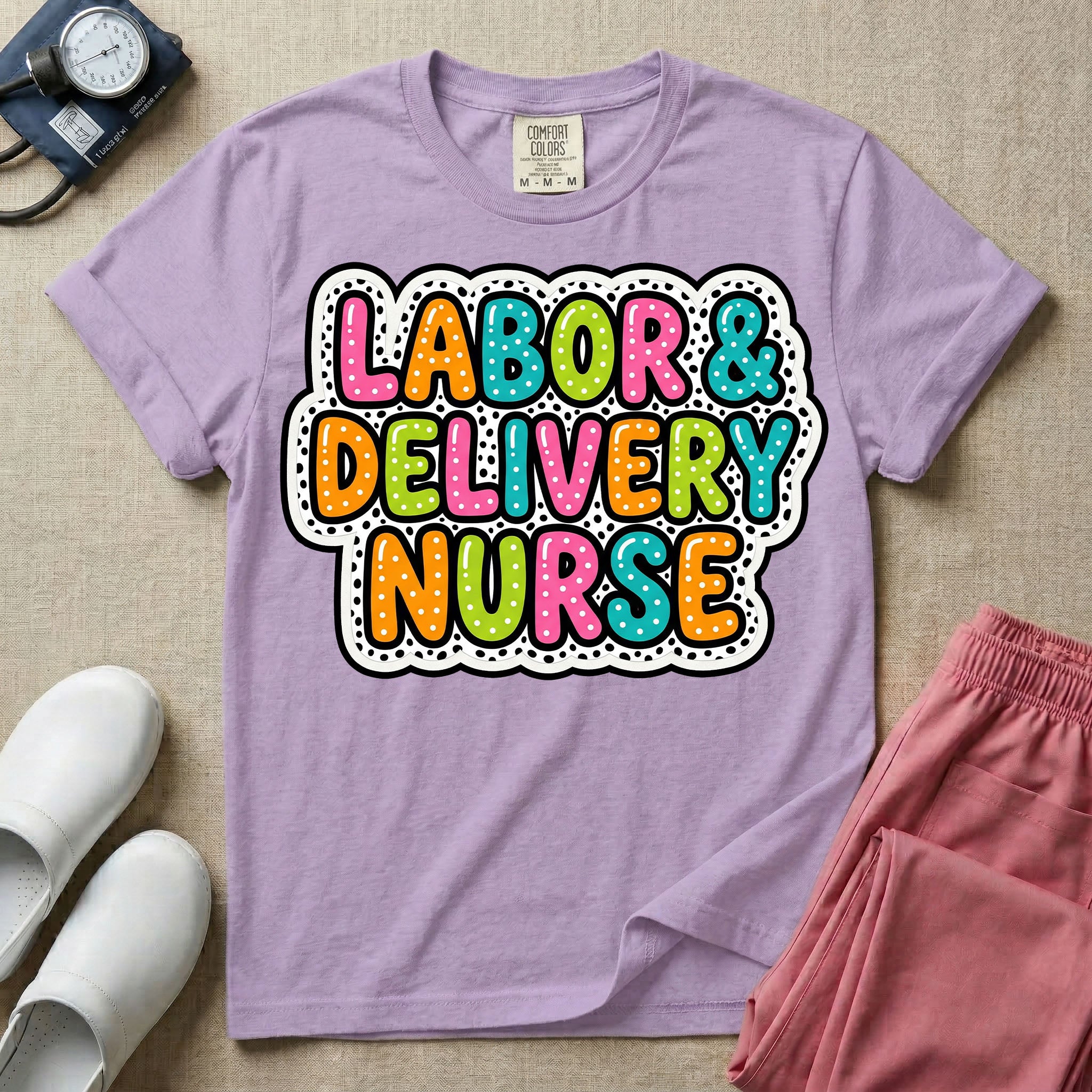 A graphic t-shirt for a Labor and Delivery unit featuring the text 'LABOR & DELIVERY NURSE' in bright, multicolored bubble lettering with white dots, framed by a contrasting black and white spotted background pattern.