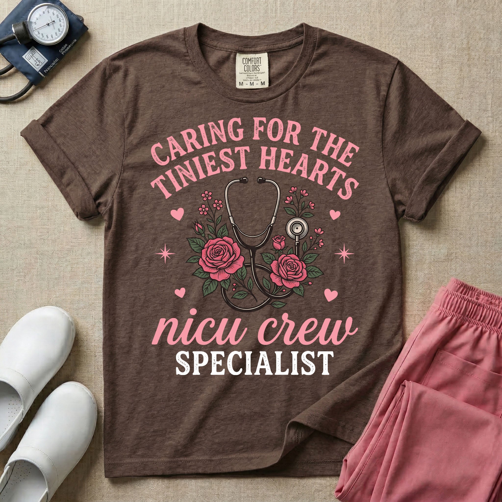 NICU nurse graphic featuring a stethoscope intertwined with pink roses, stars, and hearts, surrounded by the text "Caring for the tiniest hearts nicu crew SPECIALIST".