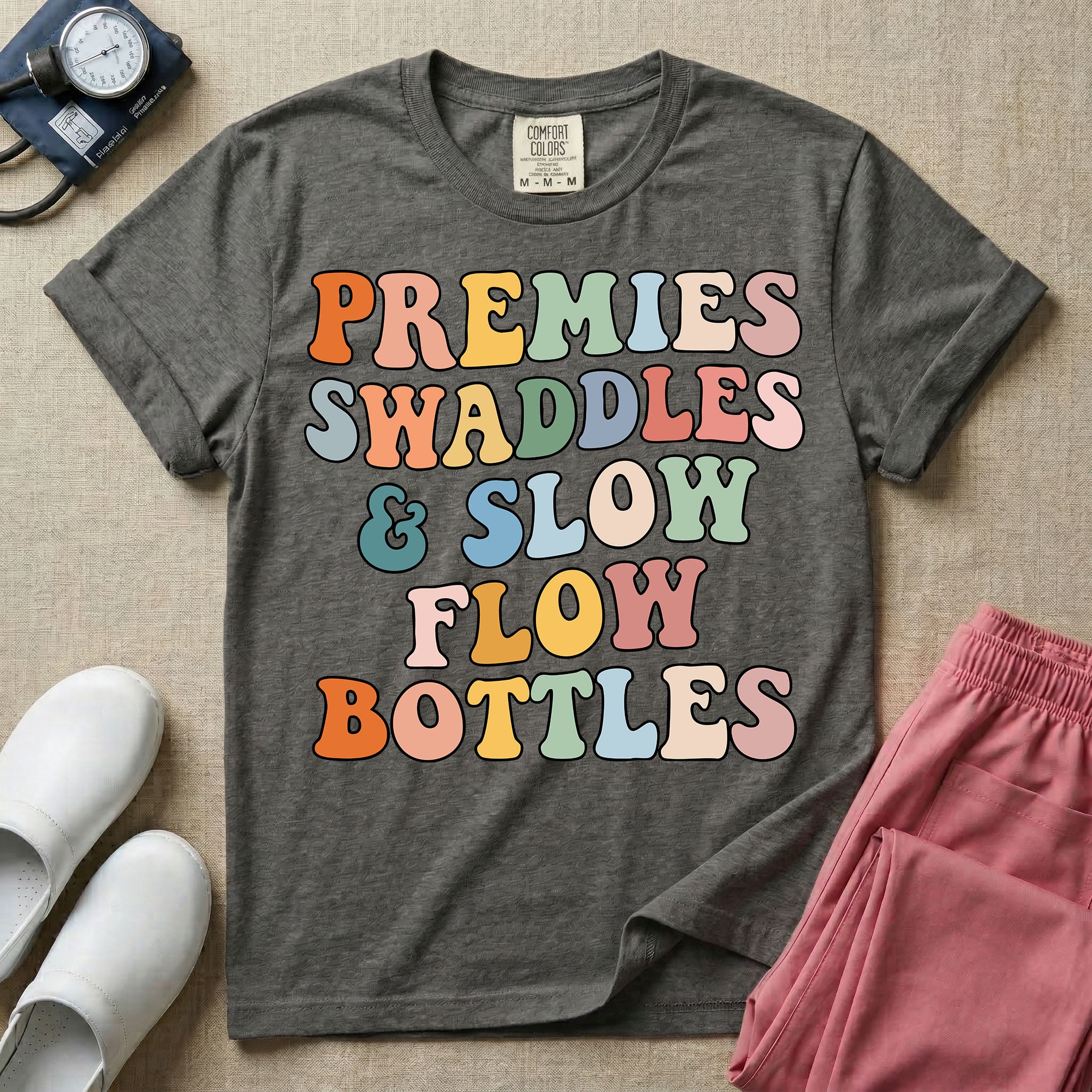 NICU nurse graphic featuring the phrase PREMIES SWADDLES & SLOW FLOW BOTTLES written in colorful retro wavy bubble letters.