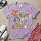 NICU nurse graphic featuring the phrase PREMIES SWADDLES & SLOW FLOW BOTTLES written in colorful retro wavy bubble letters.
