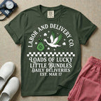 A retro Labor and Delivery nurse design featuring a flying stork carrying a sack with a shamrock, surrounded by stars and clovers, above a checkered border and the text "Labor and Delivery Co. Loads Of Lucky Little Bundles Daily Deliveries Est. Mar 17".
