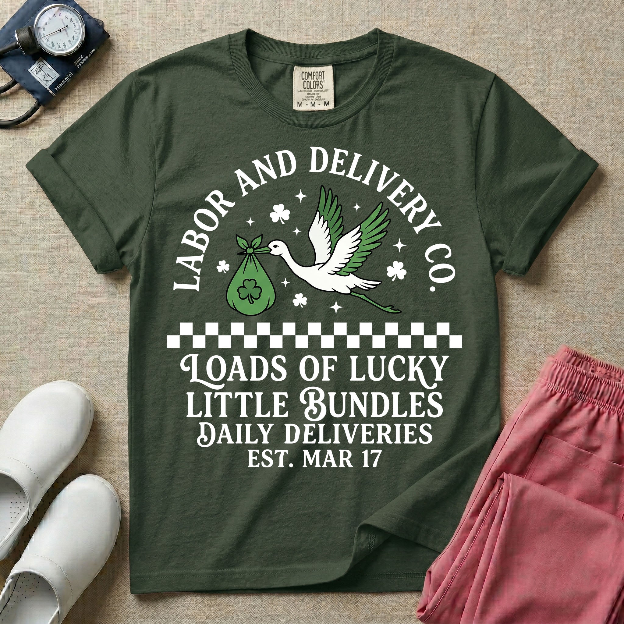 A retro Labor and Delivery nurse design featuring a flying stork carrying a sack with a shamrock, surrounded by stars and clovers, above a checkered border and the text "Labor and Delivery Co. Loads Of Lucky Little Bundles Daily Deliveries Est. Mar 17".