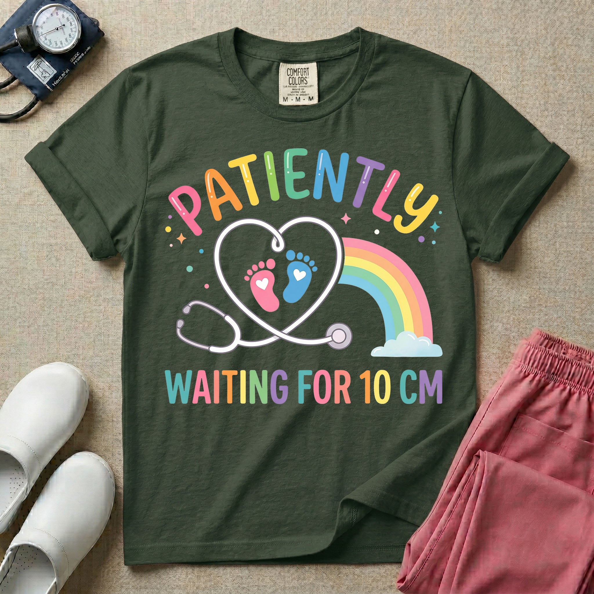 A cute Labor and Delivery and Midwife design featuring a heart-shaped stethoscope enclosing pink and blue baby footprints next to a pastel rainbow and small stars, accompanied by the text "PATIENTLY WAITING FOR 10 CM" in colorful lettering.