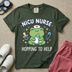 A cute Neonatal Intensive Care Unit nurse design featuring a smiling green frog wearing a nurse hat with a red heart, holding a baby bottle, accompanied by a floating pacifier, safety pin, stars, and hearts, surrounded by the text "NICU NURSE HOPPING TO HELP".