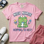 A cute Neonatal Intensive Care Unit nurse design featuring a smiling green frog wearing a nurse hat with a red heart, holding a baby bottle, accompanied by a floating pacifier, safety pin, stars, and hearts, surrounded by the text "NICU NURSE HOPPING TO HELP".