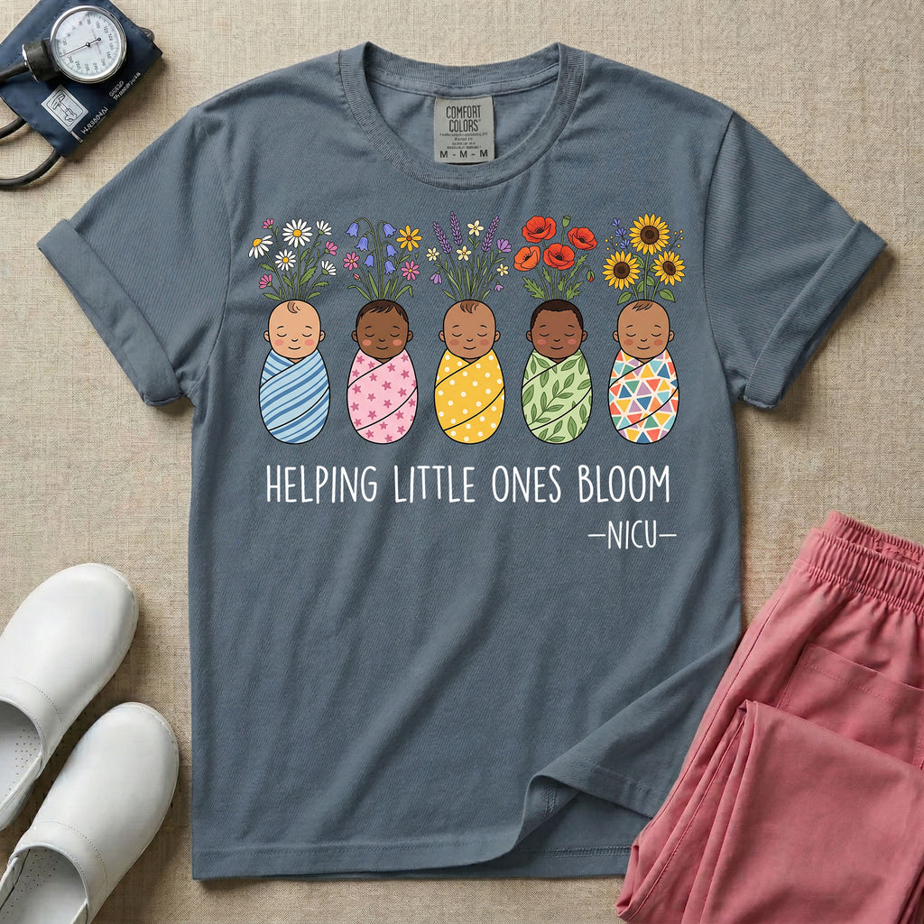 A Neonatal Intensive Care Unit nurse design featuring five peacefully sleeping, diverse babies in differently patterned swaddles with vibrant flowers like sunflowers and daisies blooming from the tops of their heads, positioned above the text "HELPING LITTLE ONES BLOOM -NICU-".