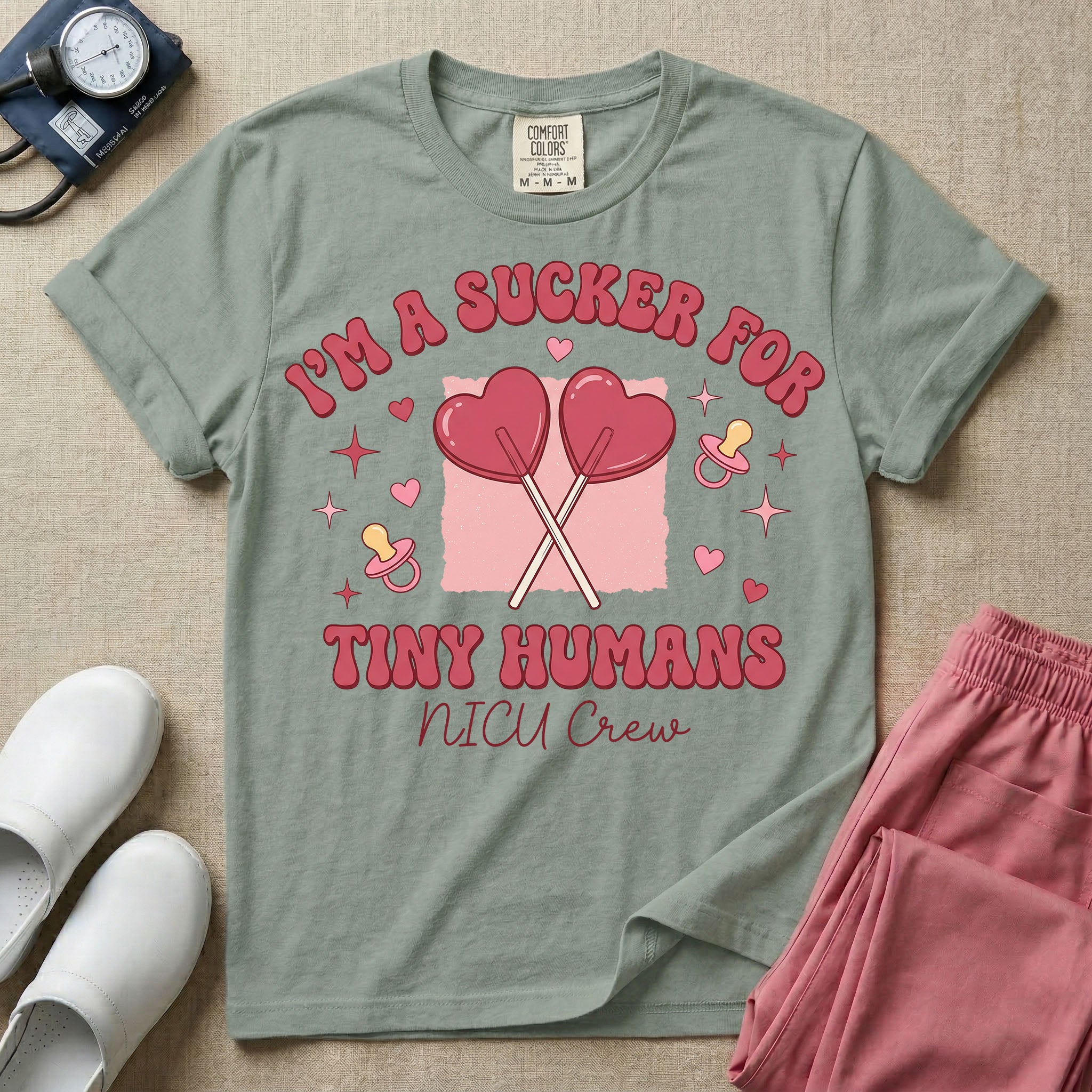 A retro Neonatal Intensive Care Unit nurse design featuring two crossed heart-shaped lollipops over a textured pink square, flanked by two baby pacifiers, sparkling stars, and small hearts, surrounded by the humorous text "I'M A SUCKER FOR TINY HUMANS NICU Crew" in a red and pink groovy font.