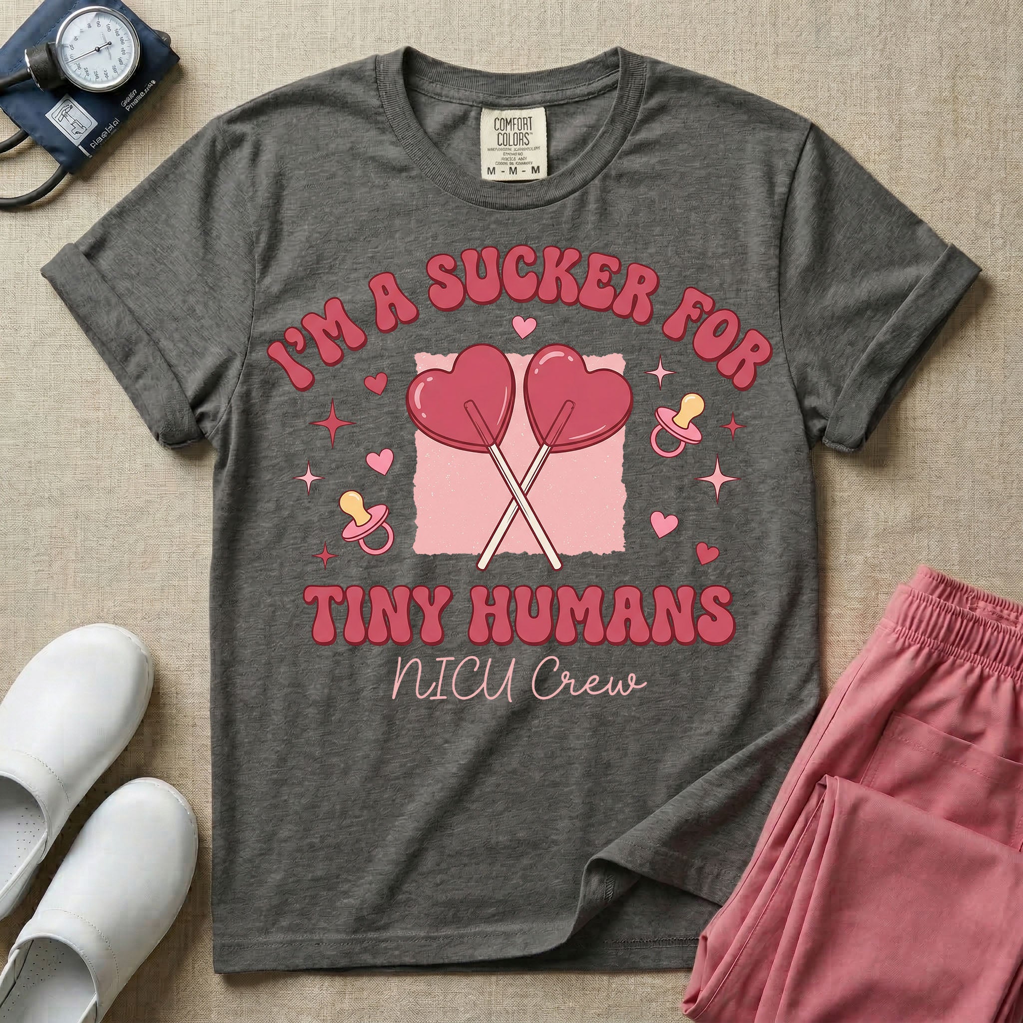 A retro Neonatal Intensive Care Unit nurse design featuring two crossed heart-shaped lollipops over a textured pink square, flanked by two baby pacifiers, sparkling stars, and small hearts, surrounded by the humorous text "I'M A SUCKER FOR TINY HUMANS NICU Crew" in a red and pink groovy font.