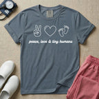 A t-shirt featuring minimalist line art of a peace sign, a heart, and baby footprints above the text "peace, love & tiny humans" designed for NICU, labor and delivery, and pediatric nurses.