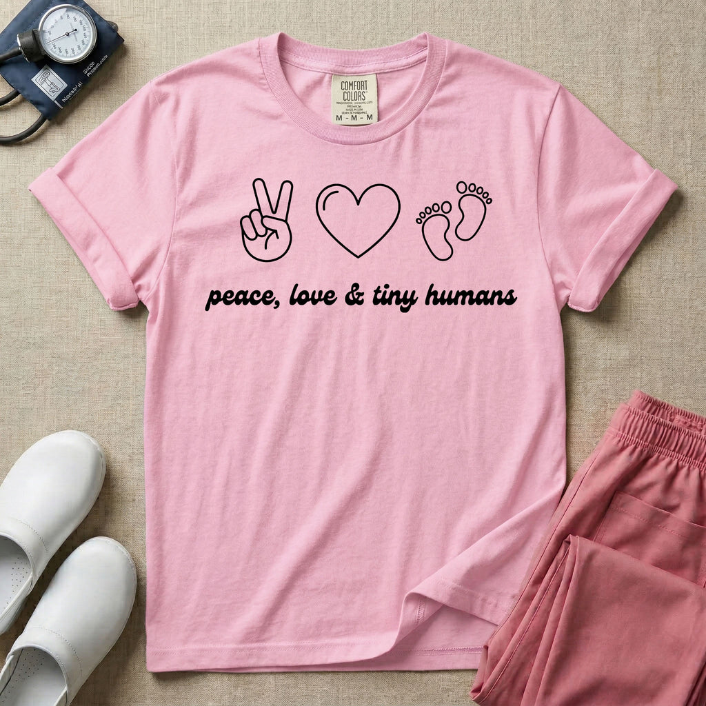 A t-shirt featuring minimalist line art of a peace sign, a heart, and baby footprints above the text "peace, love & tiny humans" designed for NICU, labor and delivery, and pediatric nurses.