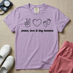 A t-shirt featuring minimalist line art of a peace sign, a heart, and baby footprints above the text "peace, love & tiny humans" designed for NICU, labor and delivery, and pediatric nurses.