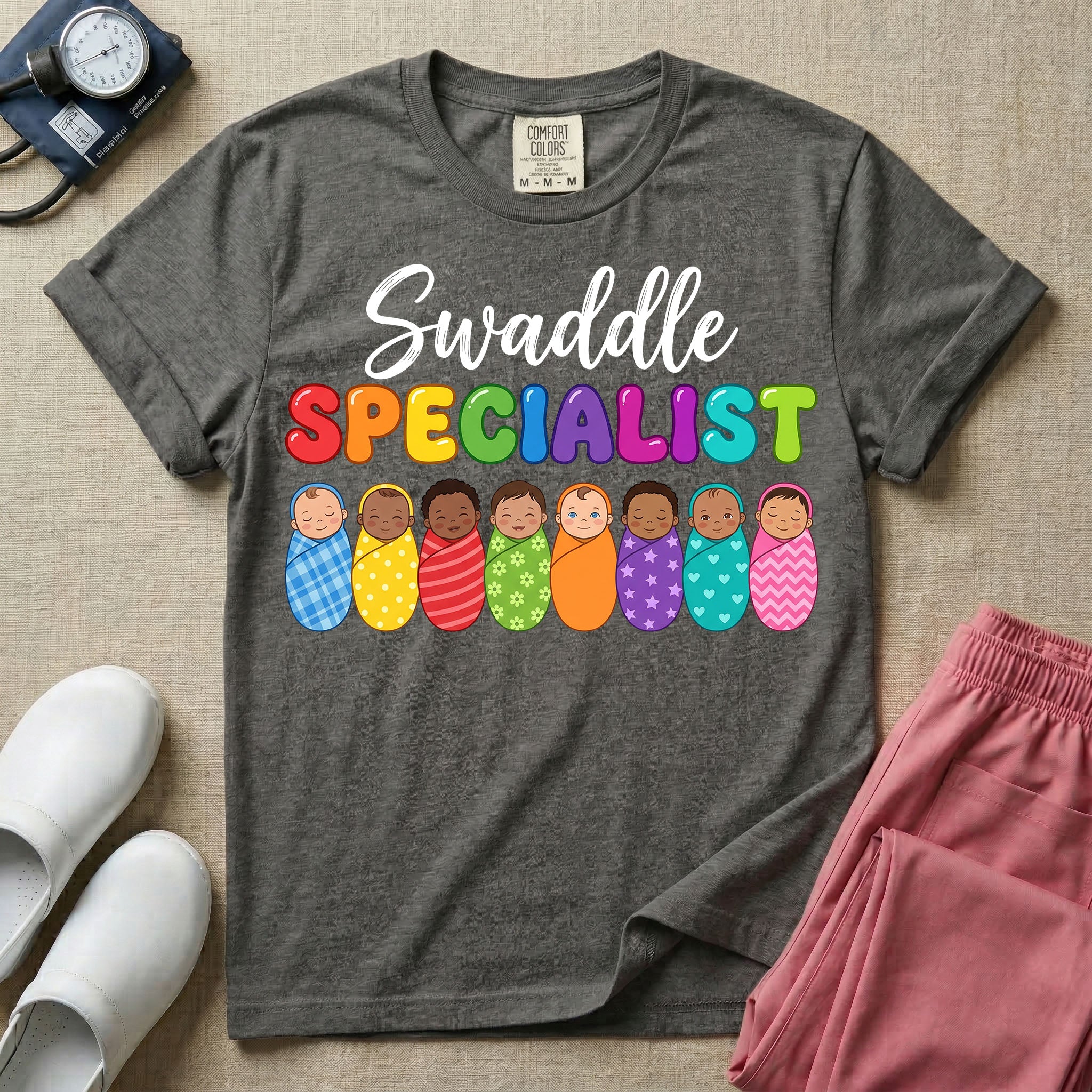 A graphic featuring the word Swaddle in white cursive above the word SPECIALIST in bright, colorful bubble letters, resting over a row of eight diverse babies wrapped in colorful patterned swaddles, designed for NICU, labor and delivery, postpartum, and pediatric nurses.