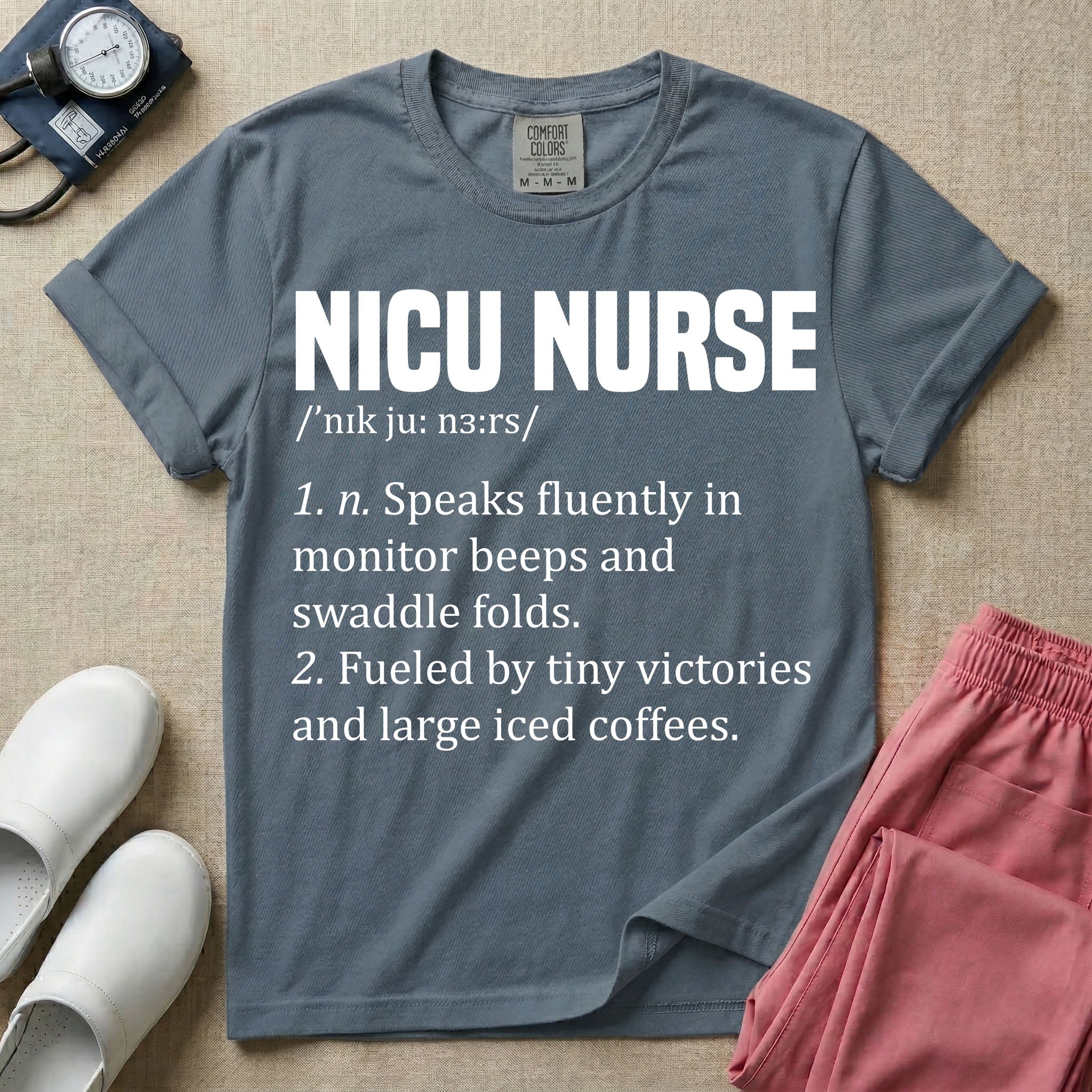 A graphic featuring a dictionary definition style layout with the bold heading NICU NURSE, followed by the phonetic pronunciation and two humorous definitions reading "1. n. Speaks fluently in monitor beeps and swaddle folds." and "2. Fueled by tiny victories and large iced coffees." in white text.