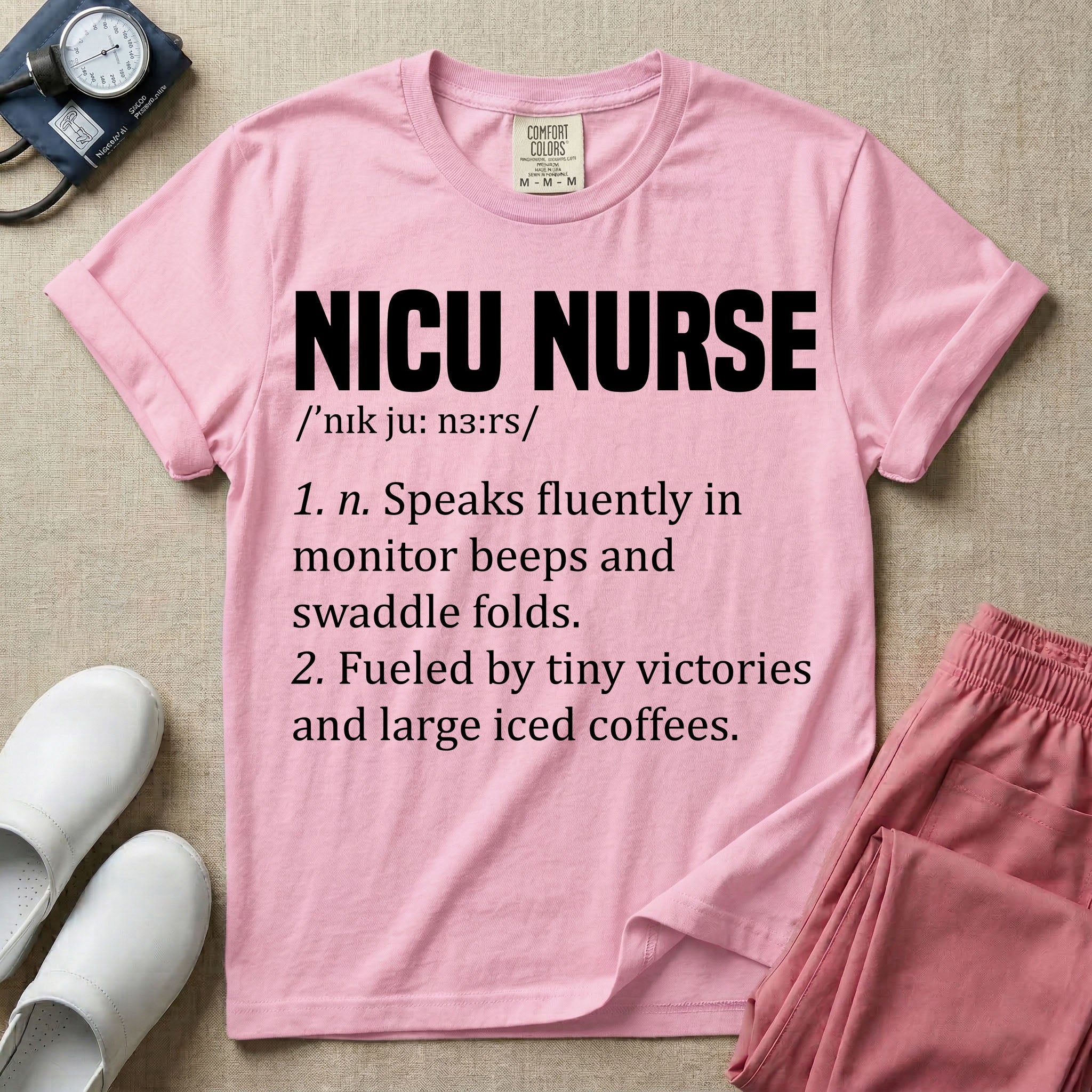 A graphic featuring a dictionary definition style layout with the bold heading NICU NURSE, followed by the phonetic pronunciation and two humorous definitions reading "1. n. Speaks fluently in monitor beeps and swaddle folds." and "2. Fueled by tiny victories and large iced coffees." in white text.