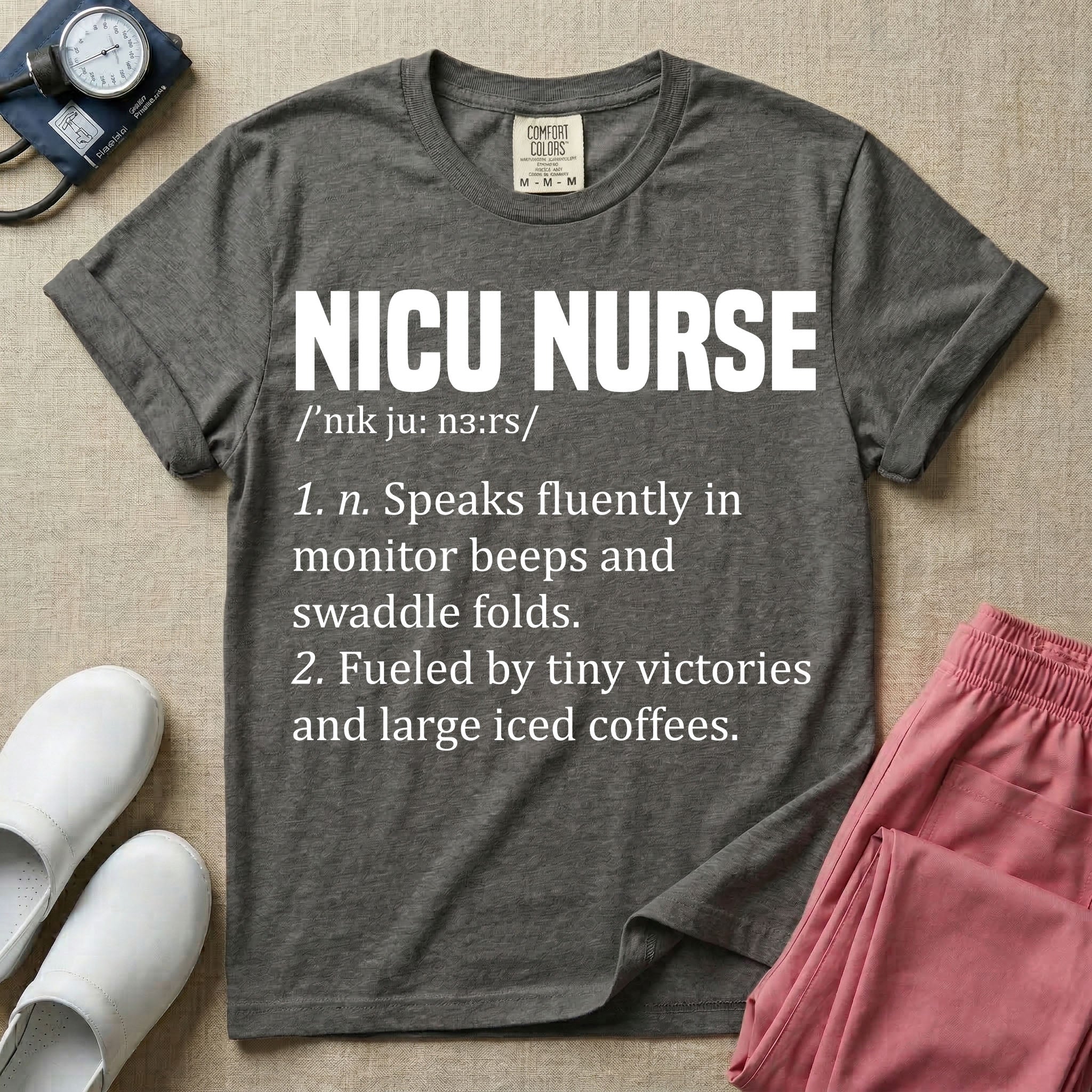 A graphic featuring a dictionary definition style layout with the bold heading NICU NURSE, followed by the phonetic pronunciation and two humorous definitions reading "1. n. Speaks fluently in monitor beeps and swaddle folds." and "2. Fueled by tiny victories and large iced coffees." in white text.