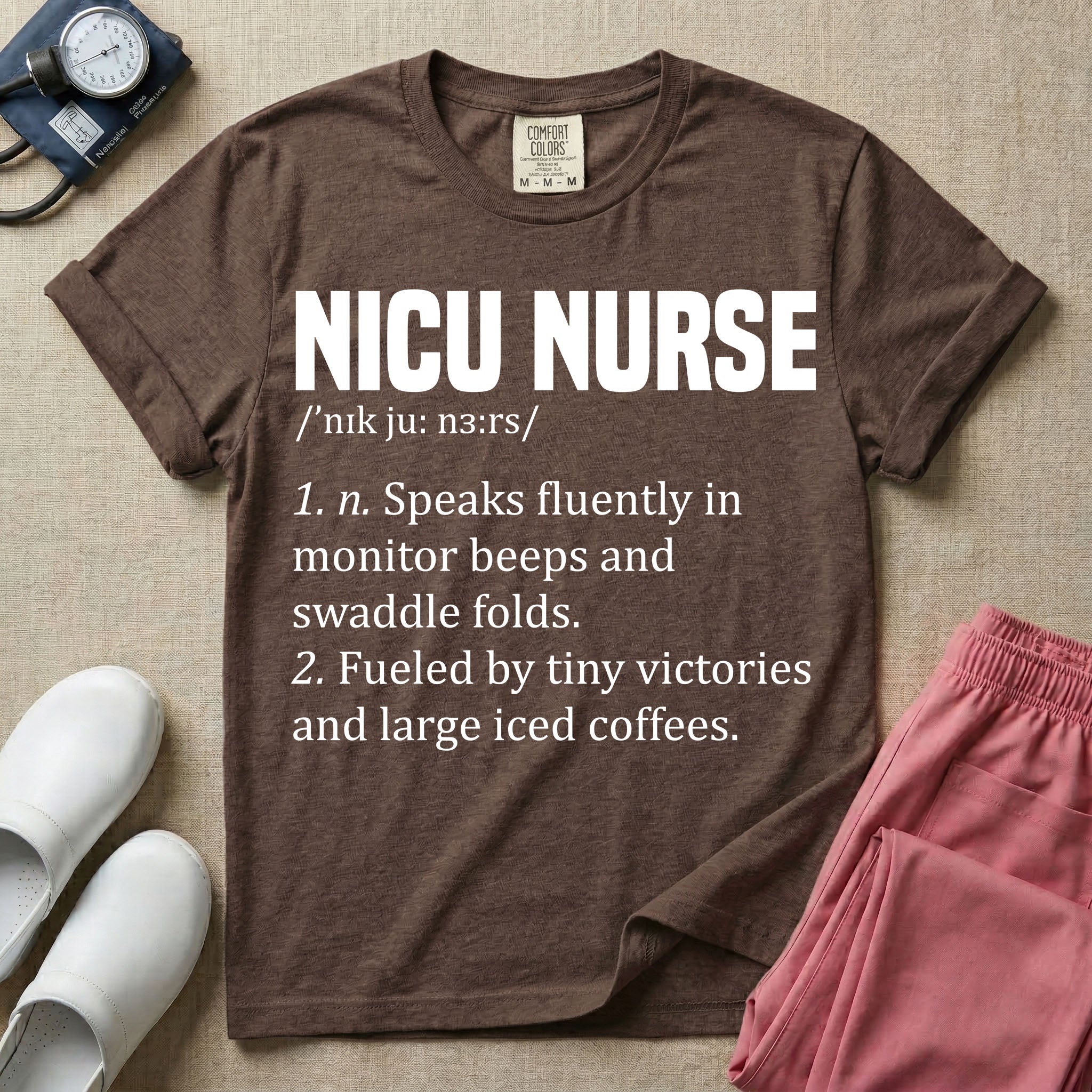 A graphic featuring a dictionary definition style layout with the bold heading NICU NURSE, followed by the phonetic pronunciation and two humorous definitions reading "1. n. Speaks fluently in monitor beeps and swaddle folds." and "2. Fueled by tiny victories and large iced coffees." in white text.