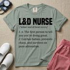 A graphic featuring a dictionary definition style layout with the bold heading L&D NURSE, followed by the phonetic pronunciation and two humorous definitions reading "1. n. The first person to tell you you're doing great." and "2. Catches babies, prevents chaos, and survives on pure adrenaline." in white text, designed for labor and delivery nurses.