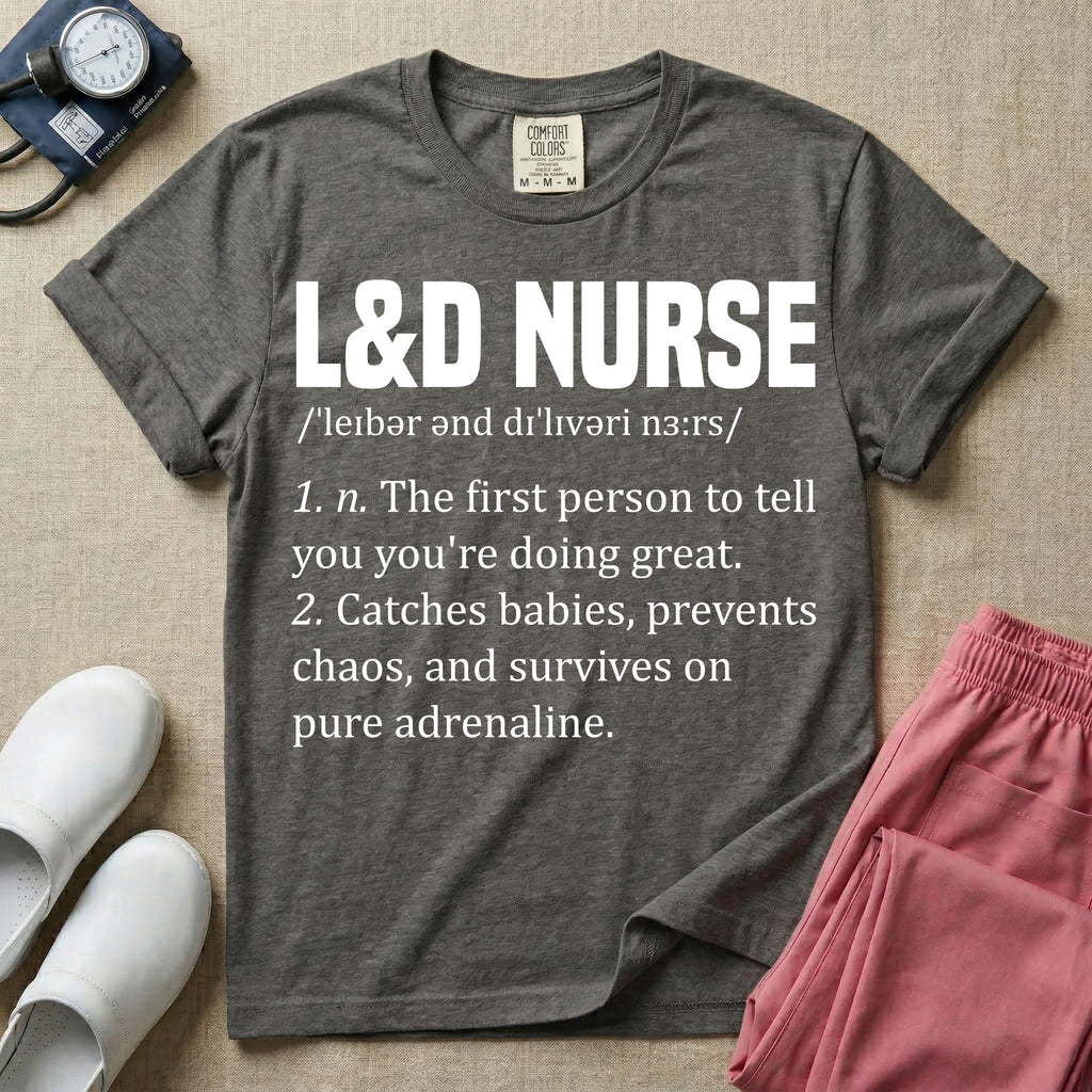 A graphic featuring a dictionary definition style layout with the bold heading L&D NURSE, followed by the phonetic pronunciation and two humorous definitions reading "1. n. The first person to tell you you're doing great." and "2. Catches babies, prevents chaos, and survives on pure adrenaline." in white text, designed for labor and delivery nurses.
