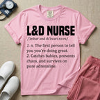 A graphic featuring a dictionary definition style layout with the bold heading L&D NURSE, followed by the phonetic pronunciation and two humorous definitions reading "1. n. The first person to tell you you're doing great." and "2. Catches babies, prevents chaos, and survives on pure adrenaline." in white text, designed for labor and delivery nurses.