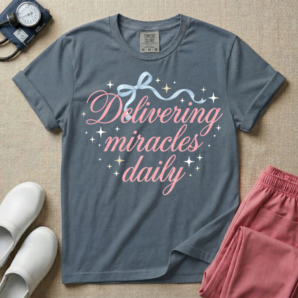 A graphic featuring the phrase "Delivering miracles daily" in elegant pink cursive script, topped with a delicate light blue ribbon bow and surrounded by sparkling stars, designed for labor and delivery, postpartum, and NICU nurses.
