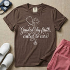 A graphic featuring a minimalist white line art stethoscope that loops into the shape of a cross, accompanied by the phrase "Guided by faith, called to care" in an elegant cursive script surrounded by small stars, designed for nurses.