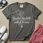 A graphic featuring a minimalist white line art stethoscope that loops into the shape of a cross, accompanied by the phrase "Guided by faith, called to care" in an elegant cursive script surrounded by small stars, designed for nurses.