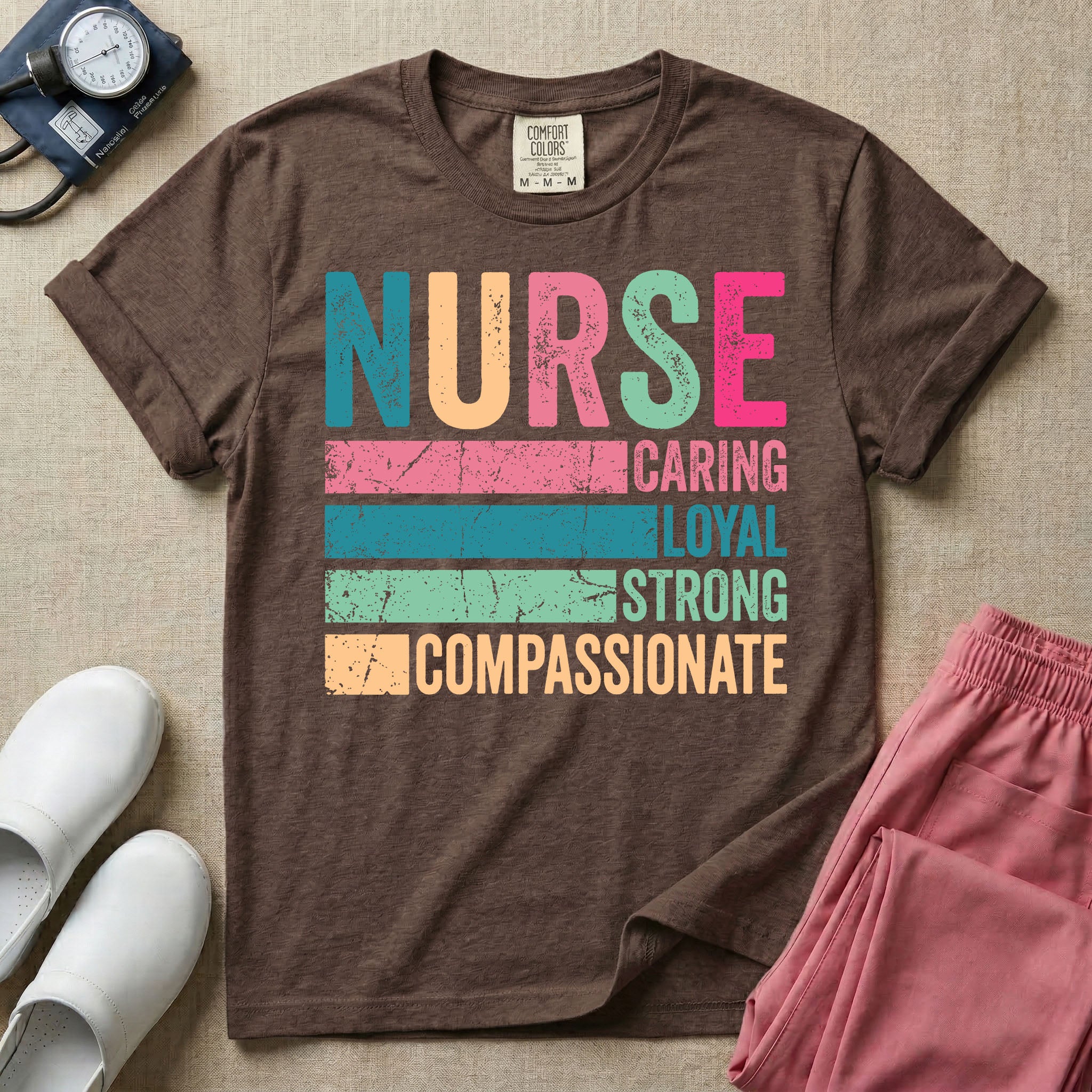 A retro graphic design for general nursing featuring the word NURSE in large, colorful distressed block letters above horizontal stripes reading CARING, LOYAL, STRONG, and COMPASSIONATE.