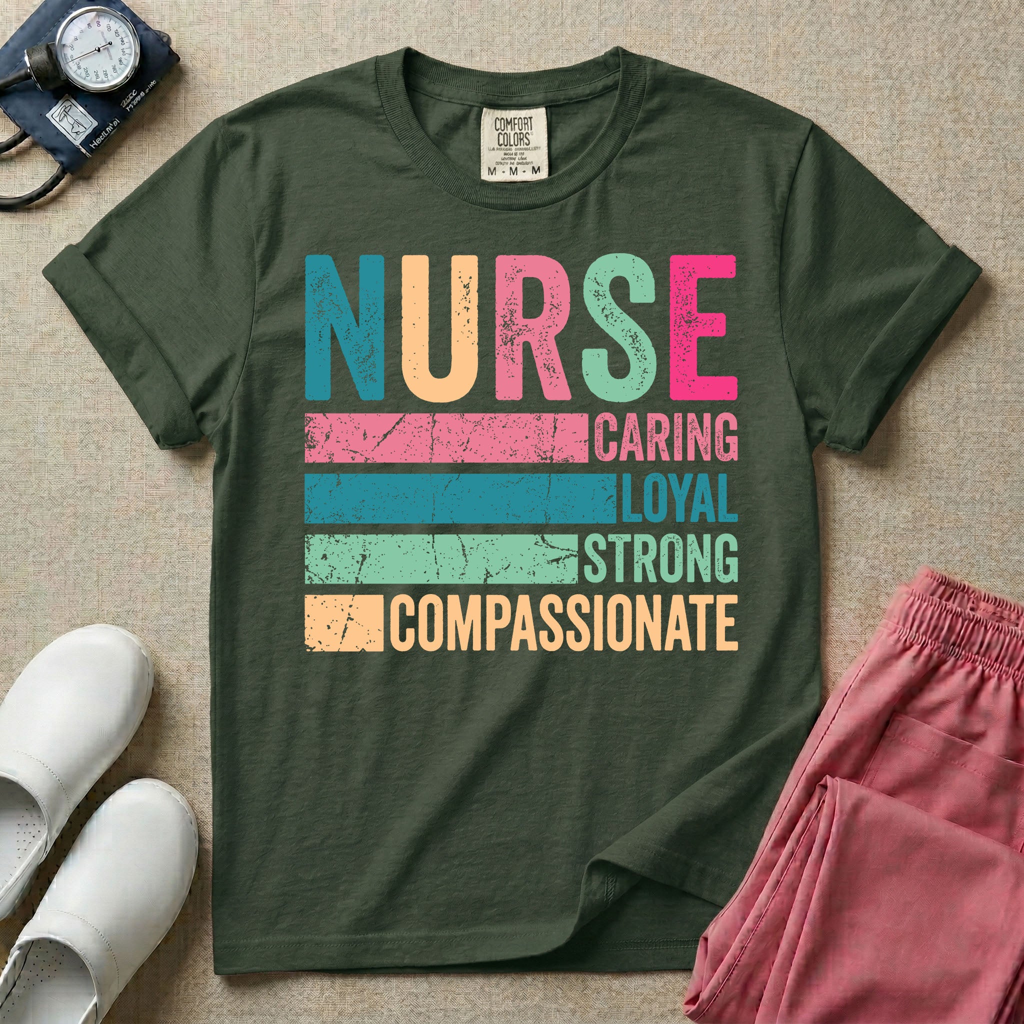A retro graphic design for general nursing featuring the word NURSE in large, colorful distressed block letters above horizontal stripes reading CARING, LOYAL, STRONG, and COMPASSIONATE.
