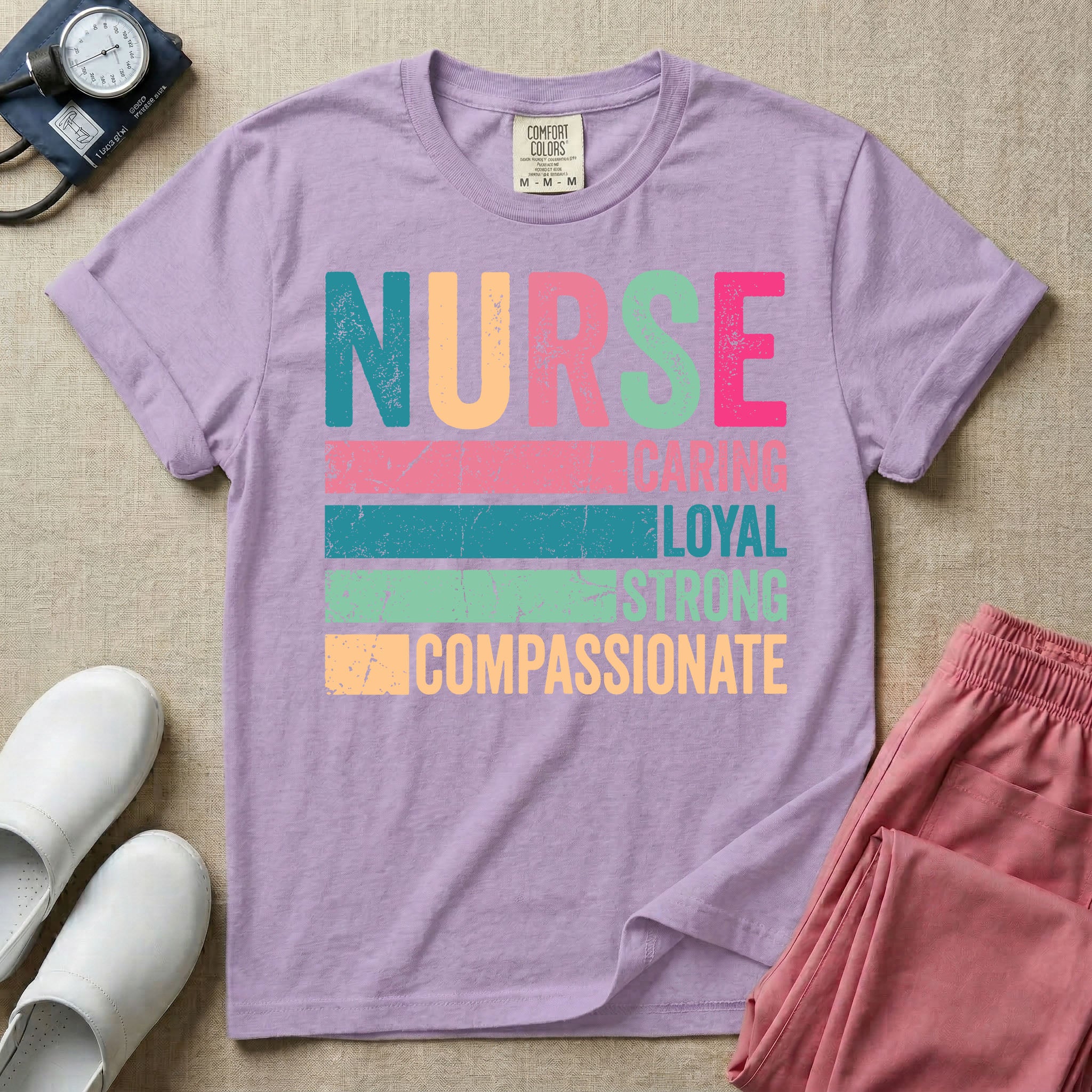 A retro graphic design for general nursing featuring the word NURSE in large, colorful distressed block letters above horizontal stripes reading CARING, LOYAL, STRONG, and COMPASSIONATE.