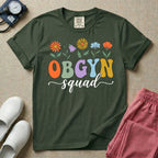 A retro floral graphic design for an OB-GYN unit featuring colorful retro flowers growing out of the letters OBGYN, with the word squad written below in a white cursive script.