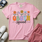 A retro floral graphic design for an OB-GYN unit featuring colorful retro flowers growing out of the letters OBGYN, with the word squad written below in a white cursive script.