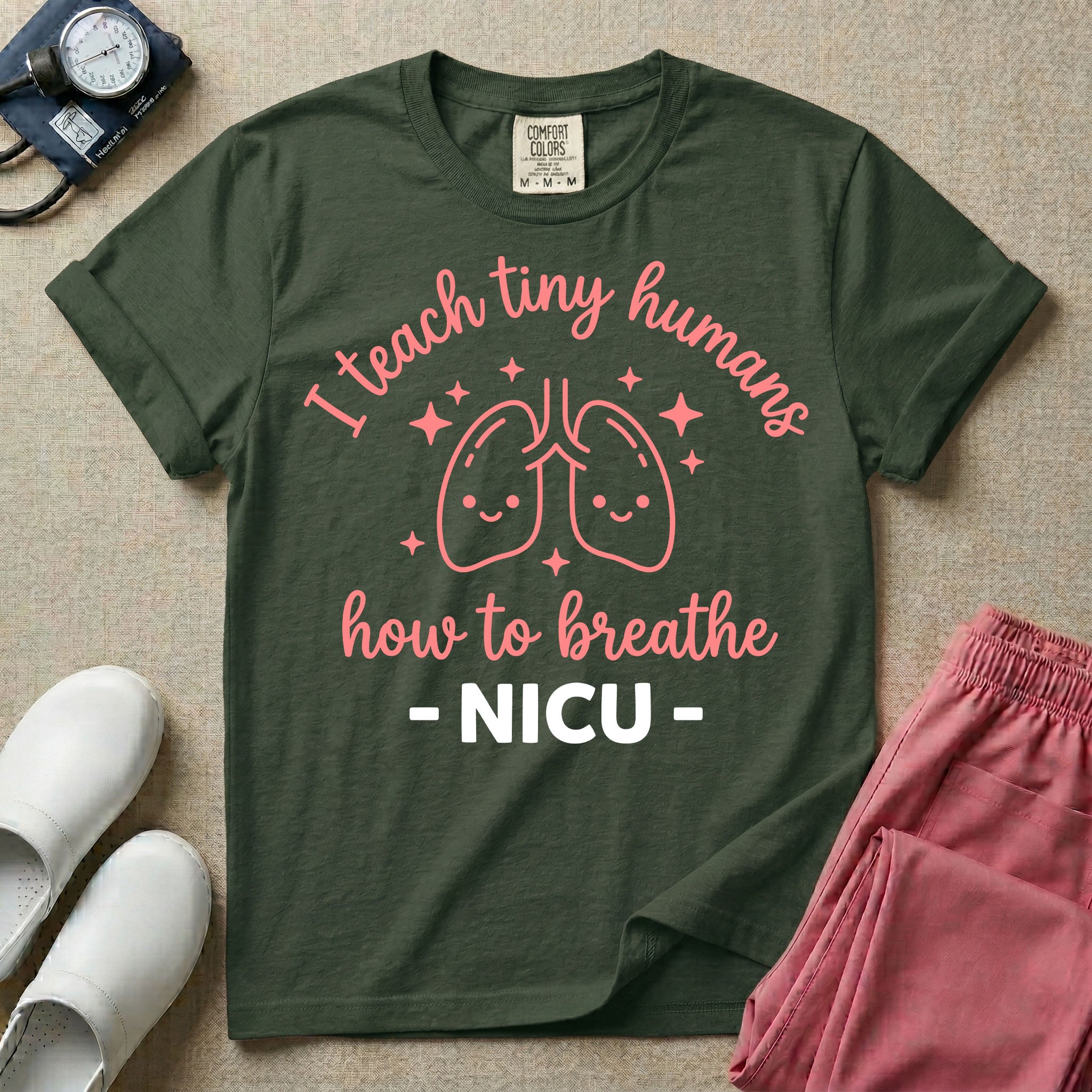 A cute graphic design for NICU nursing featuring pink illustrations of smiling lungs surrounded by little sparkles, with the text I teach tiny humans how to breathe above and NICU below.