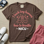 A cute graphic design for NICU nursing featuring pink illustrations of smiling lungs surrounded by little sparkles, with the text I teach tiny humans how to breathe above and NICU below.