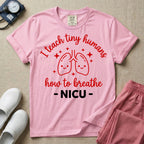 A cute graphic design for NICU nursing featuring pink illustrations of smiling lungs surrounded by little sparkles, with the text I teach tiny humans how to breathe above and NICU below.