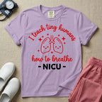 A cute graphic design for NICU nursing featuring pink illustrations of smiling lungs surrounded by little sparkles, with the text I teach tiny humans how to breathe above and NICU below.