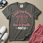 A cute graphic design for NICU nursing featuring pink illustrations of smiling lungs surrounded by little sparkles, with the text I teach tiny humans how to breathe above and NICU below.