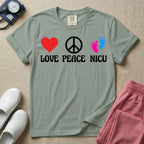 A retro graphic design for NICU nursing featuring a red heart, a white peace sign, and a pair of pink and blue baby footprints, positioned above the words LOVE PEACE NICU in a white groovy font.