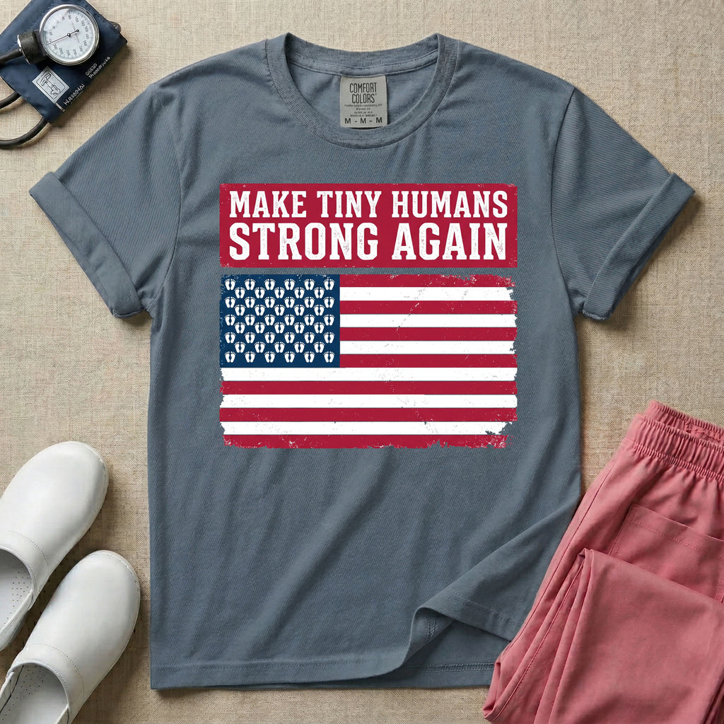 A patriotic graphic design for NICU nursing featuring the text MAKE TINY HUMANS STRONG AGAIN in white block letters against a distressed red background, positioned above a vintage American flag where the traditional stars have been replaced by rows of tiny white baby footprints.
