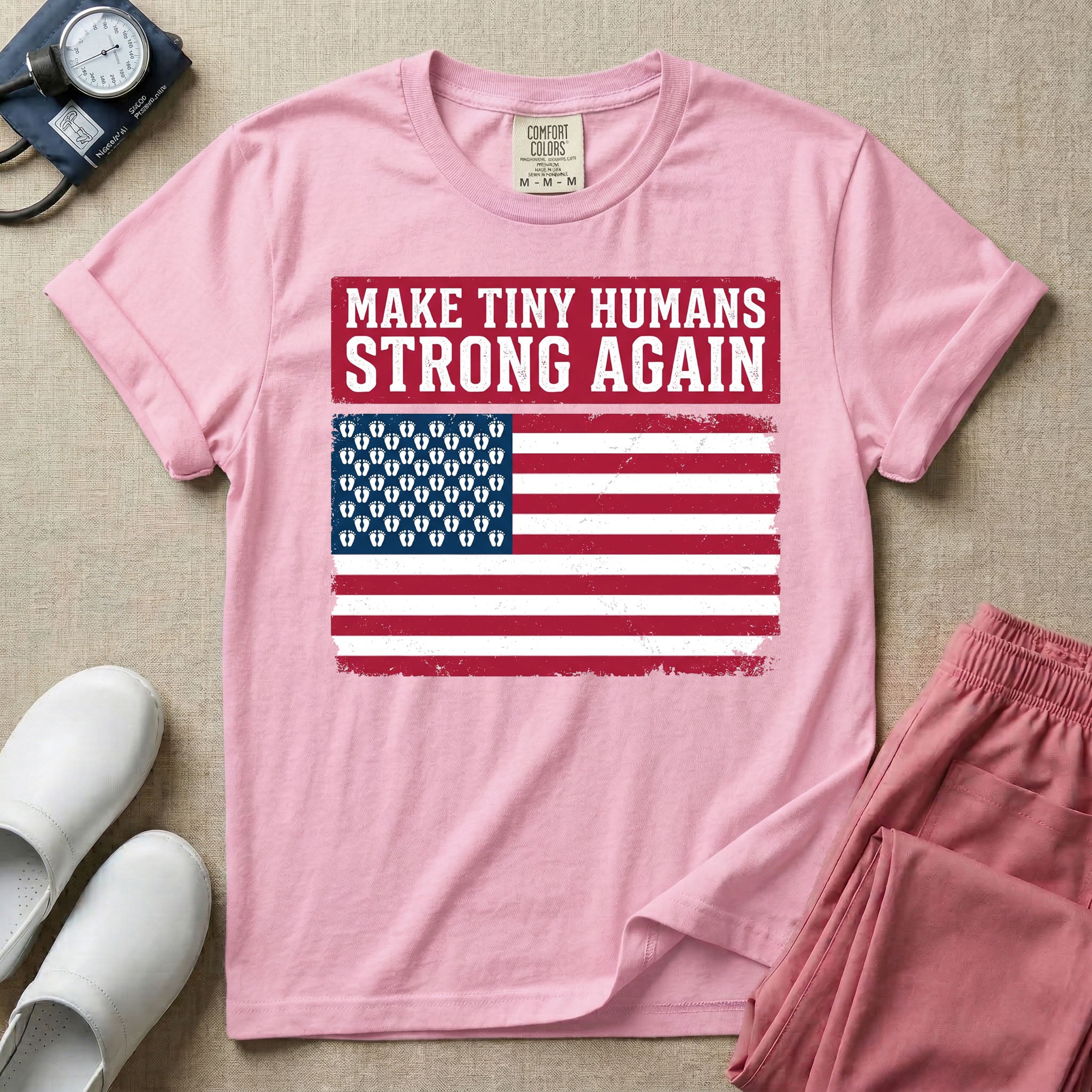 A patriotic graphic design for NICU nursing featuring the text MAKE TINY HUMANS STRONG AGAIN in white block letters against a distressed red background, positioned above a vintage American flag where the traditional stars have been replaced by rows of tiny white baby footprints.