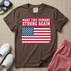 A patriotic graphic design for NICU nursing featuring the text MAKE TINY HUMANS STRONG AGAIN in white block letters against a distressed red background, positioned above a vintage American flag where the traditional stars have been replaced by rows of tiny white baby footprints.