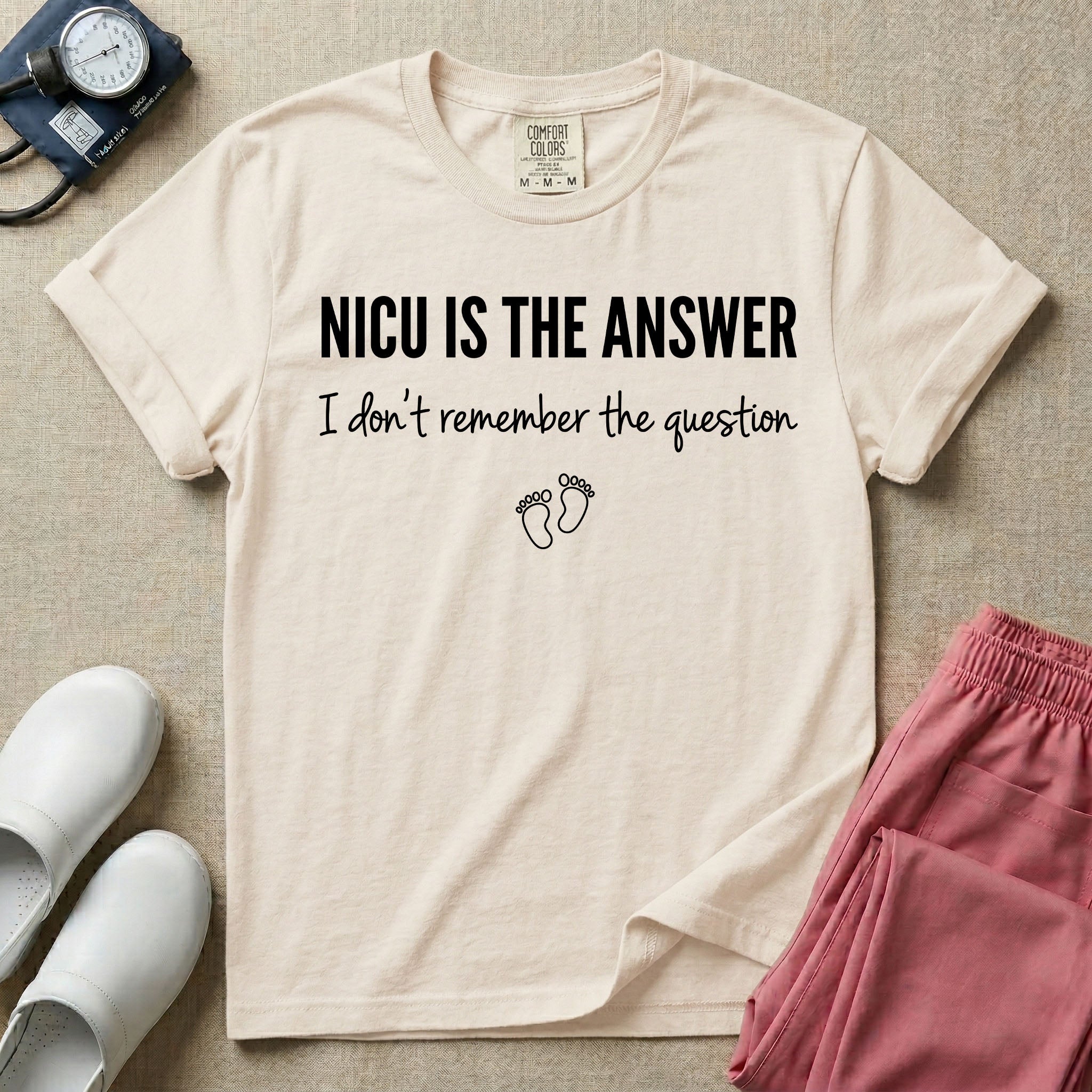 A funny neonatal intensive care unit nurse t-shirt featuring the text "NICU IS THE ANSWER I don't remember the question" with minimalist baby footprint graphics.