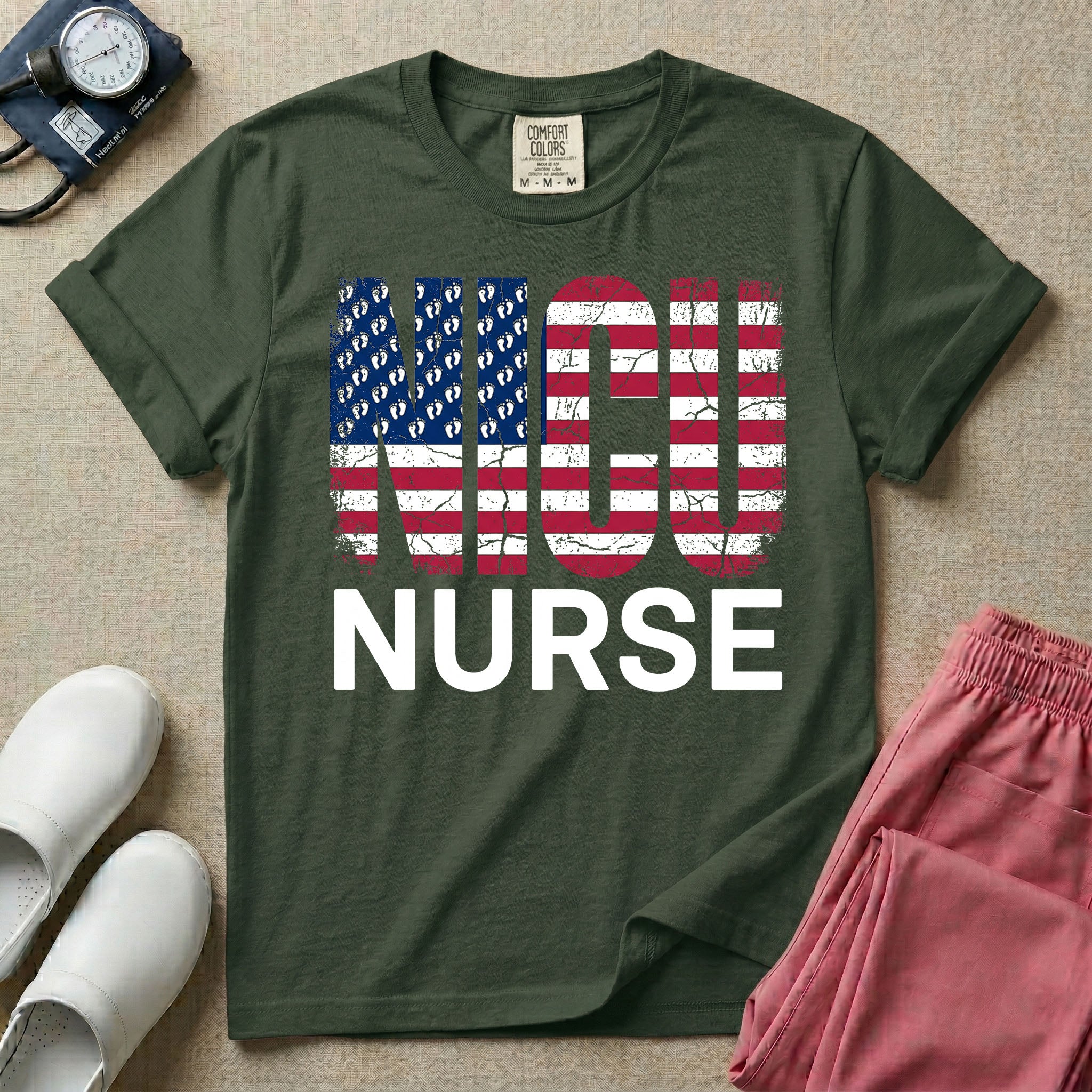 A retro neonatal intensive care unit t-shirt featuring the text "NICU NURSE" with a distressed American flag graphic inside the letters, replacing the traditional stars with tiny white baby footprints.